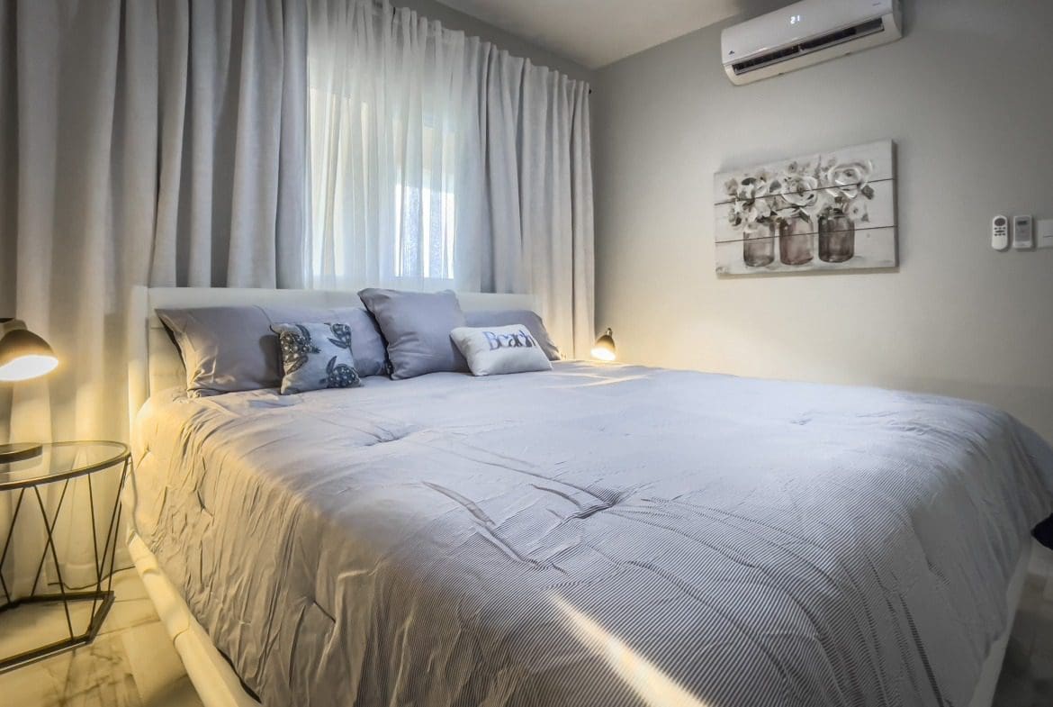 buyDRproperty Bedroom in a 1-bedroom condo with a comfortable bed and stylish decor. Sosua Real Estate