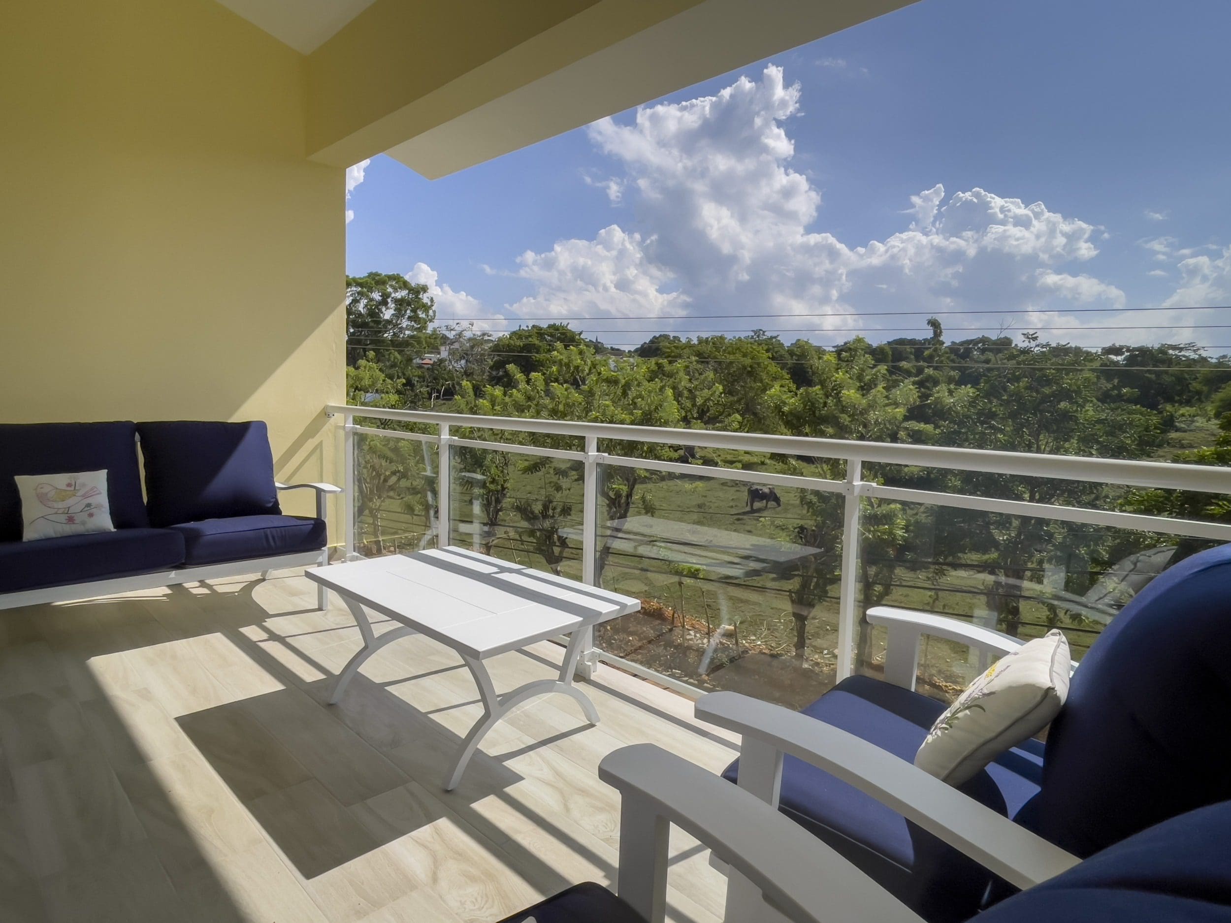 buyDRproperty Balcony of a 1-Bedroom Condo with outdoor furniture overlooking a scenic view. Sosua Real Estate