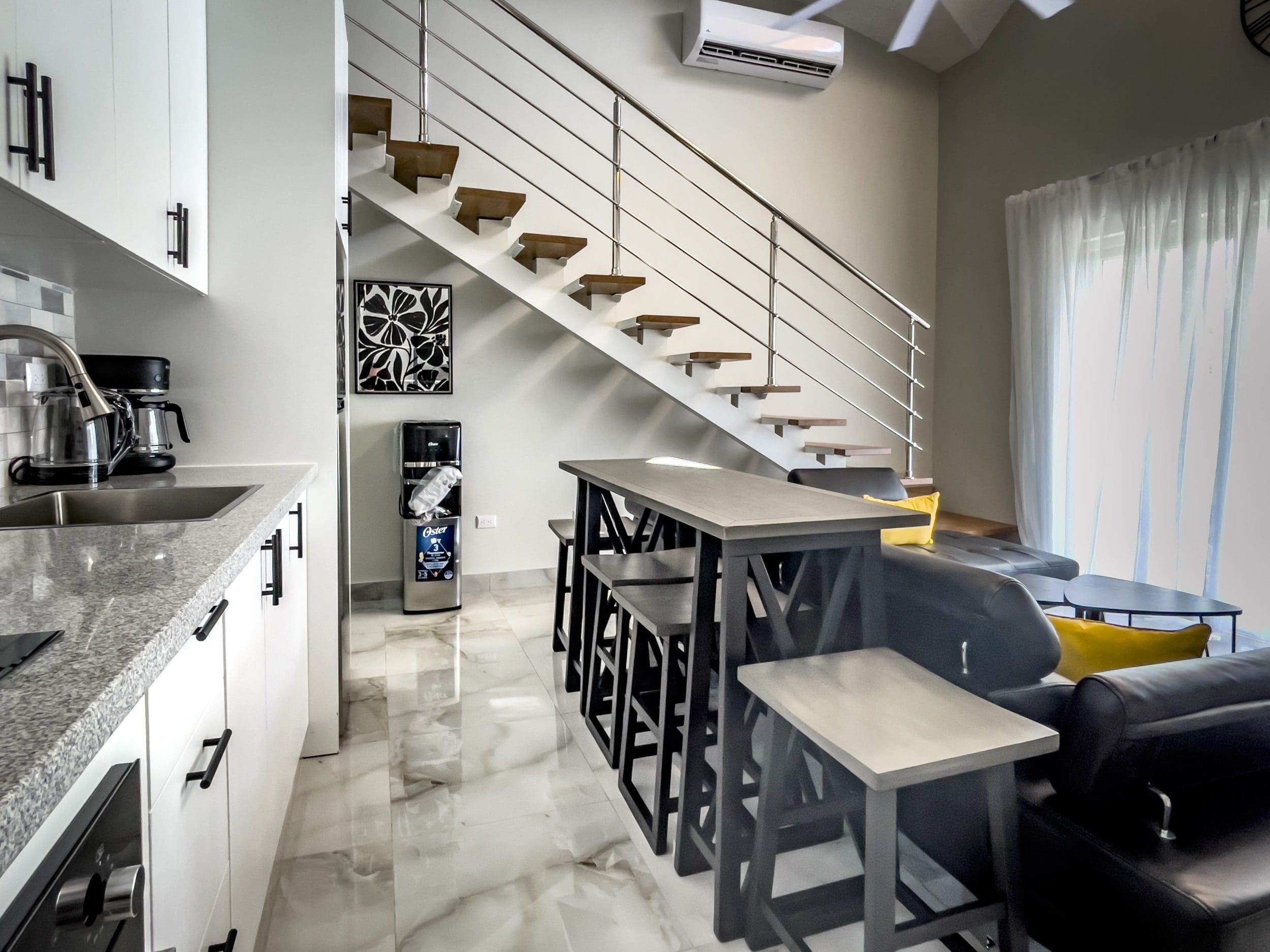 buyDRproperty Stylish 1-Bedroom Condo interior with modern kitchen, staircase, and living area. Sosua Real Estate