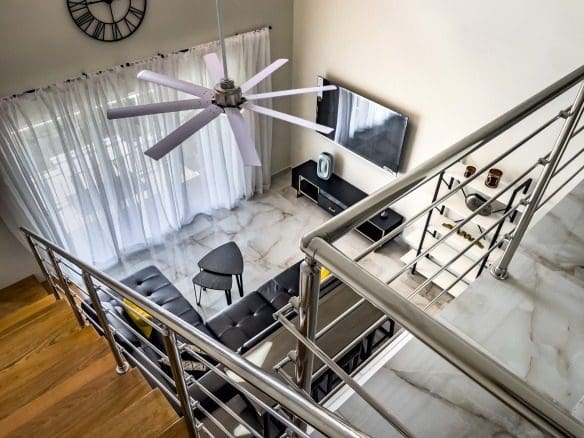 buyDRproperty Modern 1-Bedroom Condo living room with black leather sectional and marble floors. Sosua Real Estate