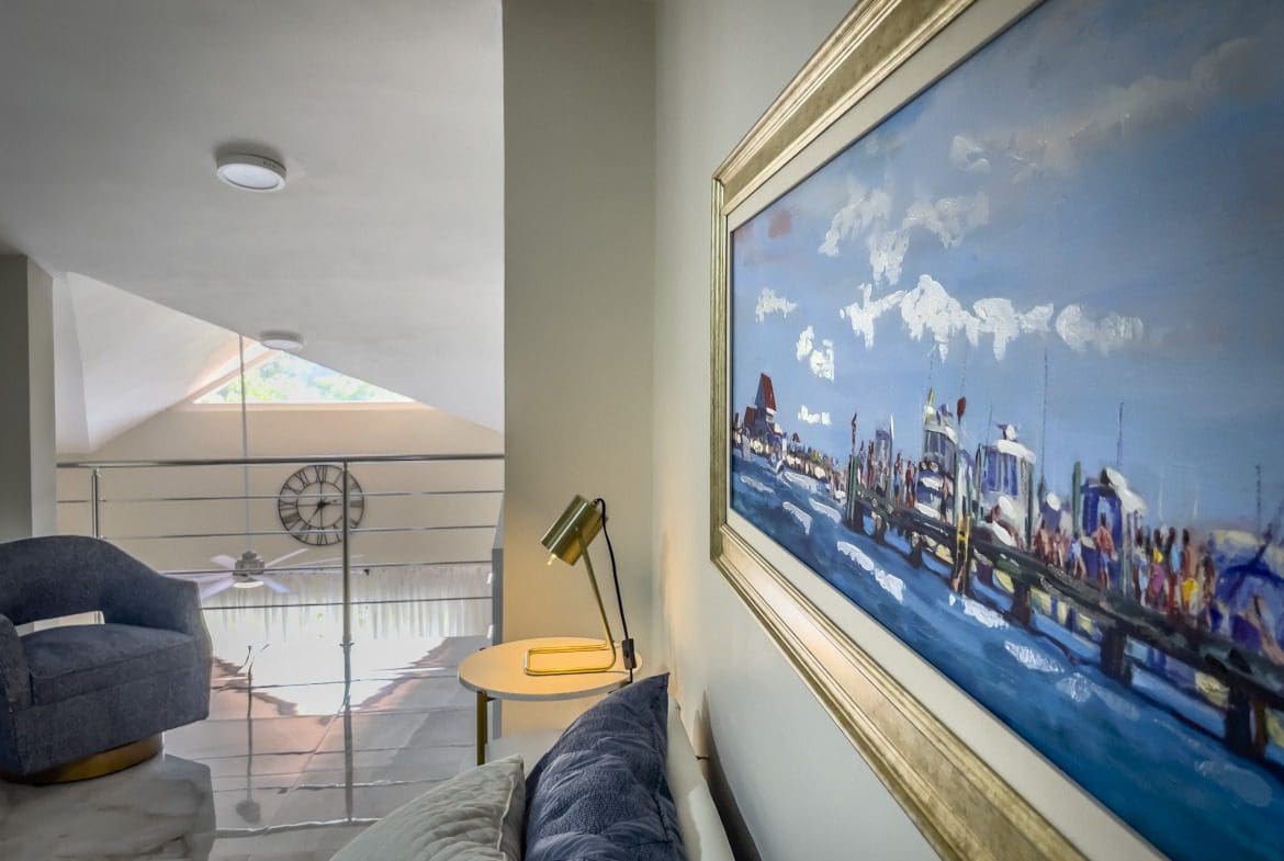 buyDRproperty Stylish 1-bedroom condo interior with a painting, loft, and chair. Sosua Real Estate