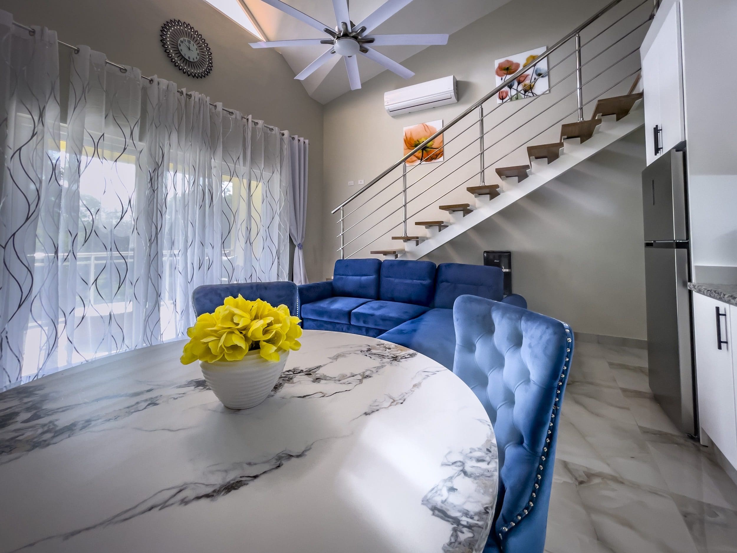 buyDRproperty Modern 1-Bedroom Condo living area with blue velvet furniture and marble table Sosua Real Estate