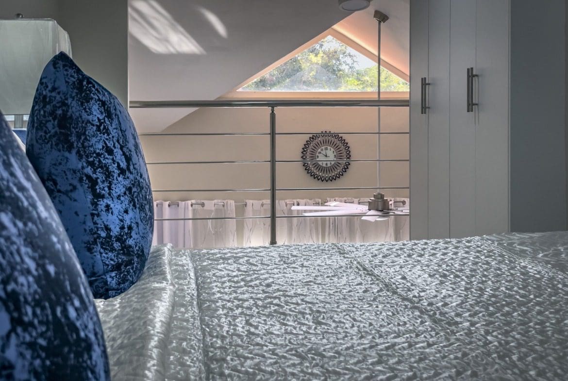 buyDRproperty Modern 1-bedroom condo bedroom with loft, blue velvet pillows on bed. Sosua Real Estate