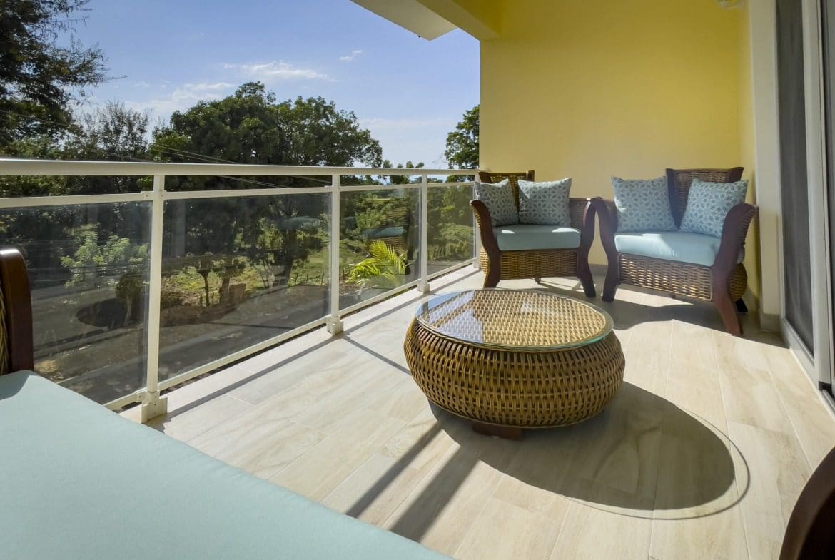 buyDRproperty Modern balcony with wicker furniture in a 1-bedroom condo. Sosua Real Estate