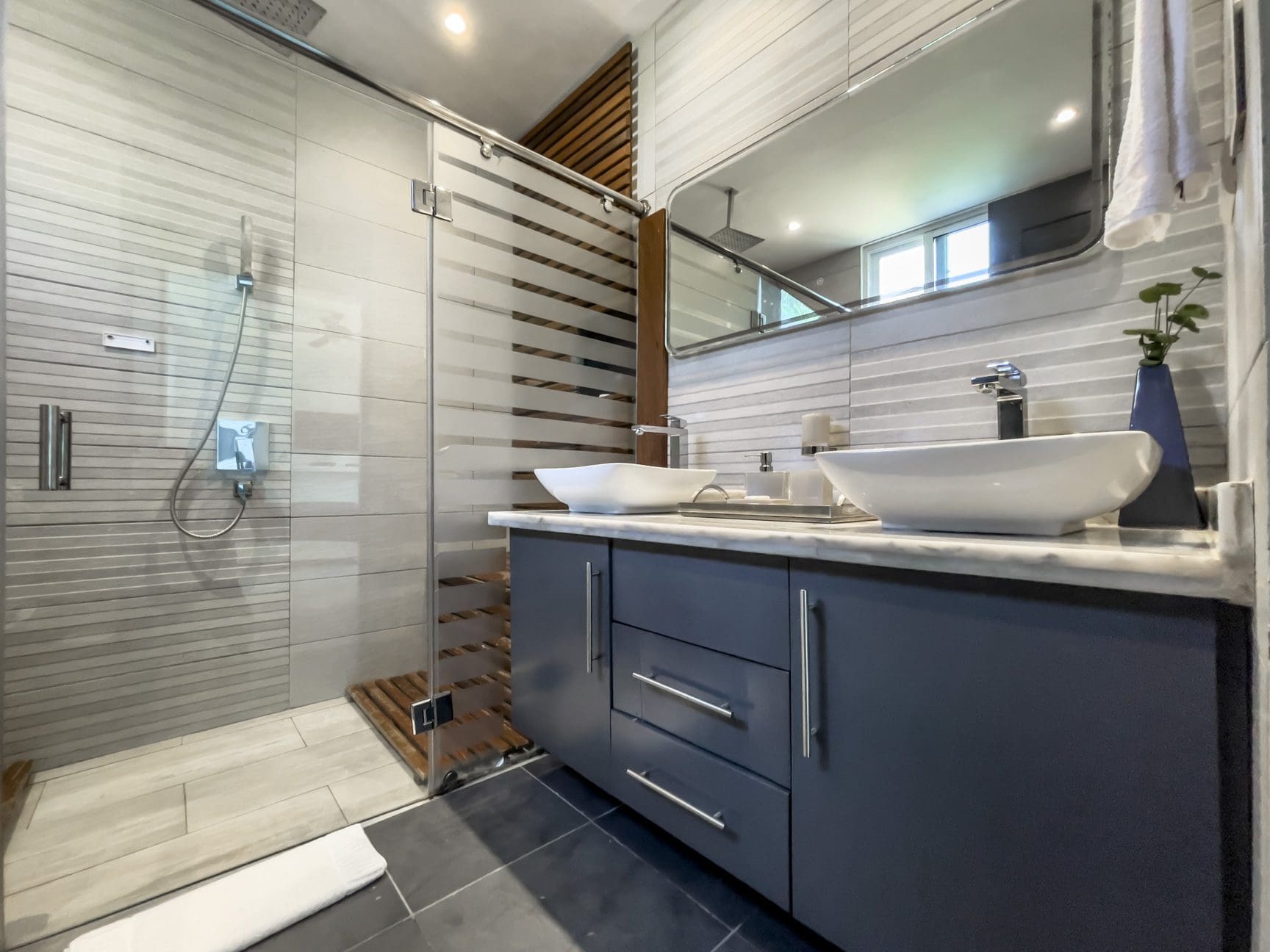 buyDRproperty Modern bathroom in a Sosúa Ocean Village villa for sale, featuring a glass shower and vessel sinks. Sosua Real Estate