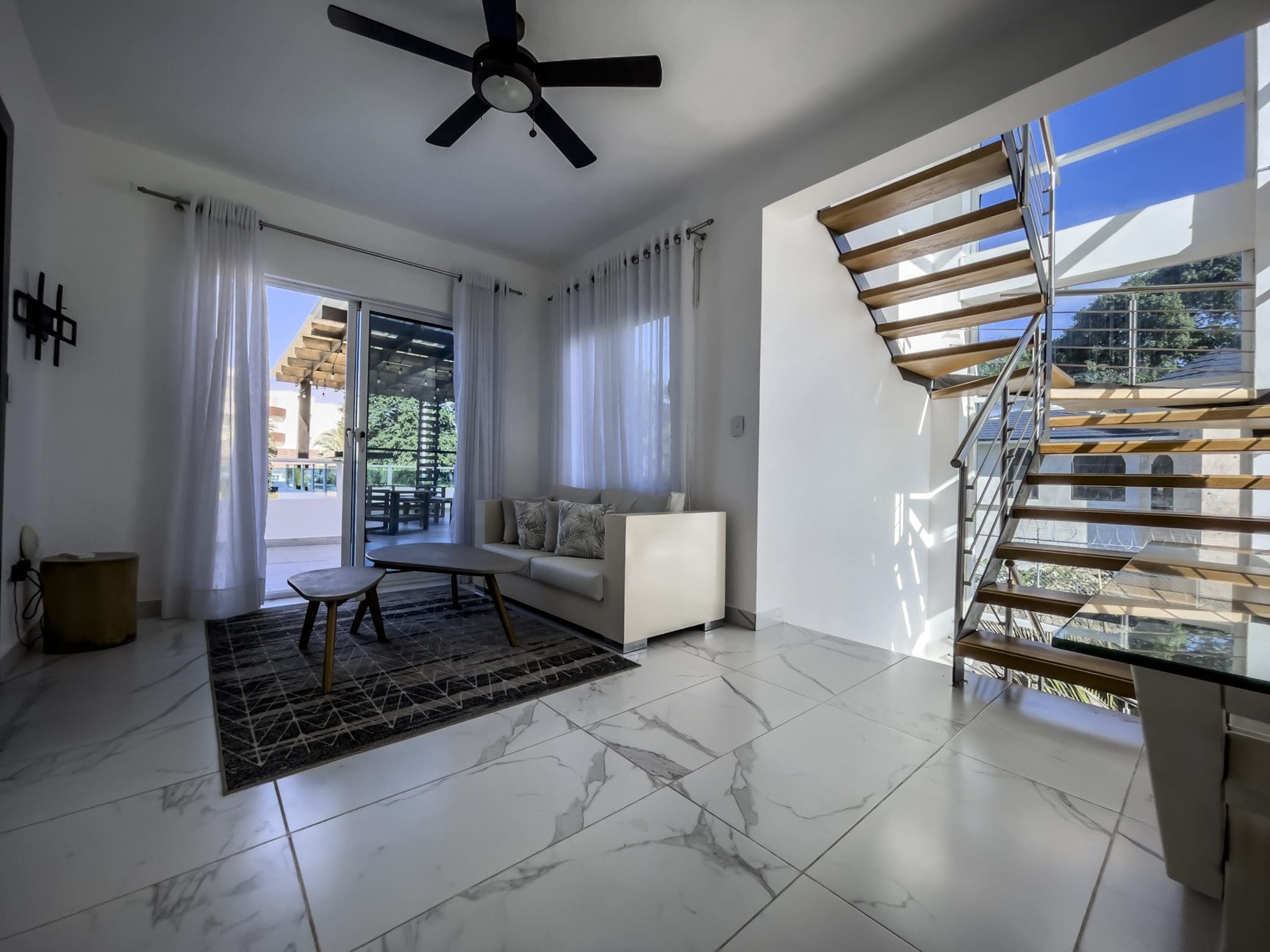 buyDRproperty Modern 3-bedroom villa interior in Sosúa Ocean Village, Dominican Republic. Features open staircase and bright living space. Sosua Real Estate