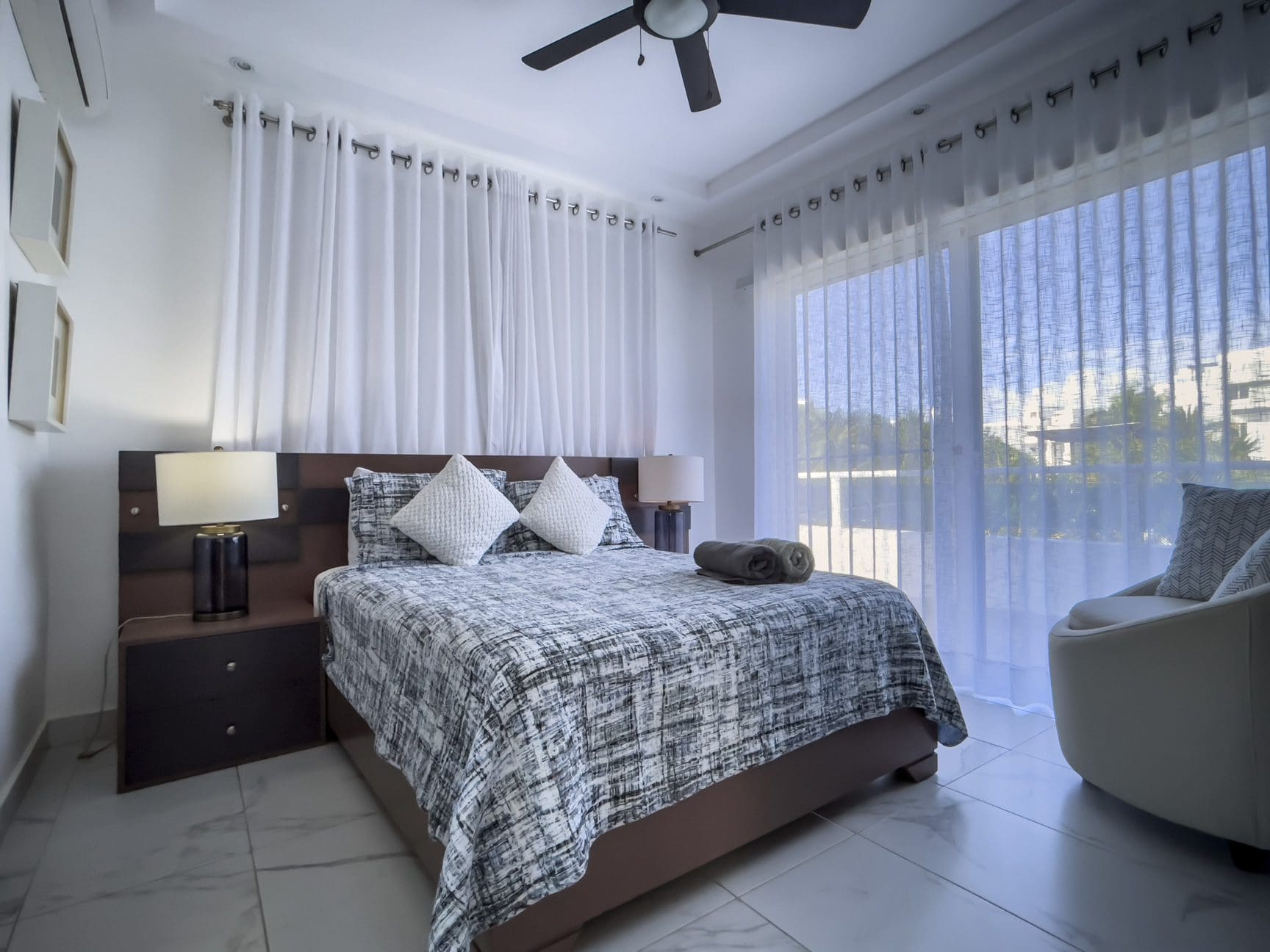 buyDRproperty Modern Sosúa Ocean Village 3-bedroom villa bedroom with bed and curtains. Sosua Real Estate