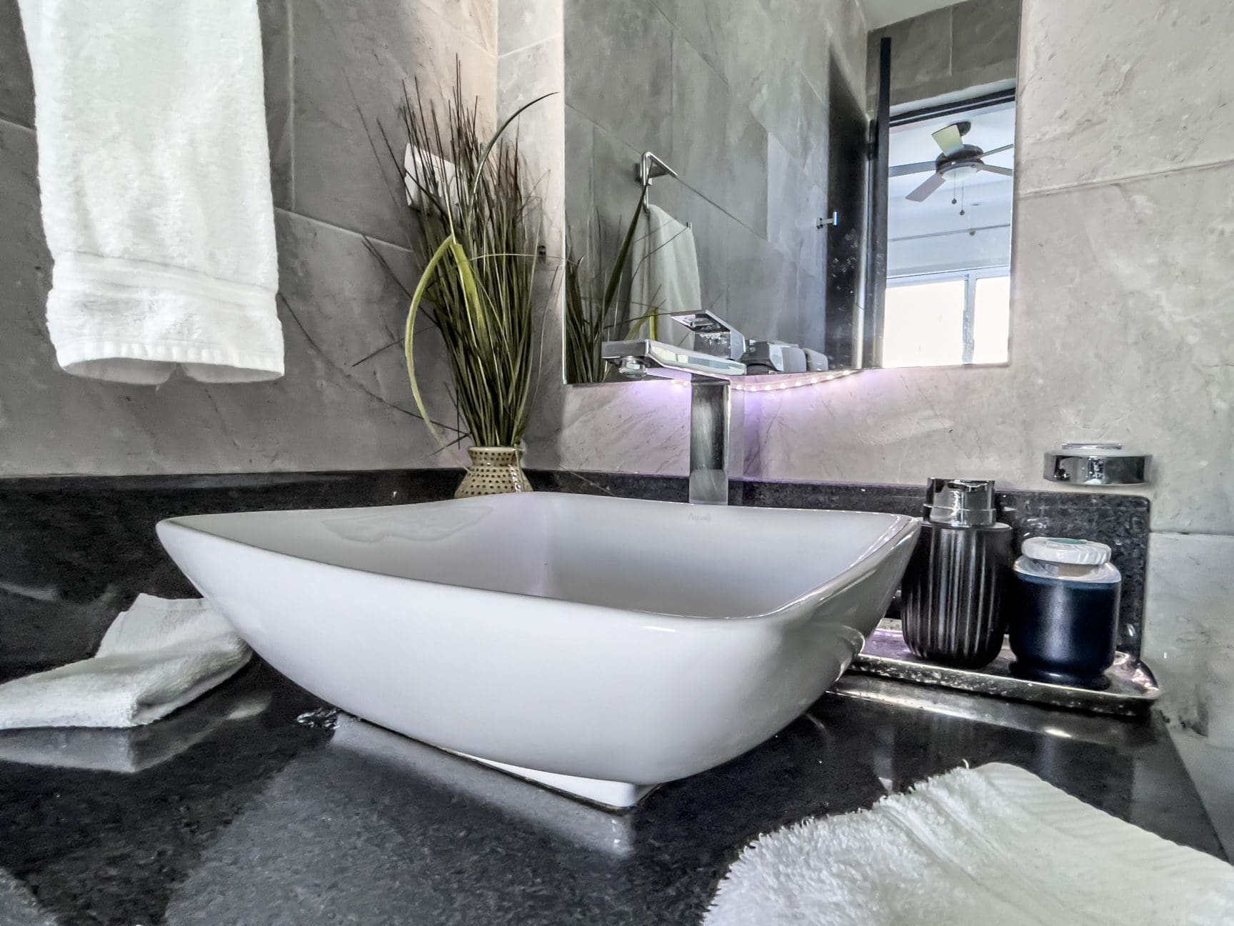 buyDRproperty Modern bathroom with a white vessel sink and black countertop. Ocean view villa in Sosúa. Sosua Real Estate