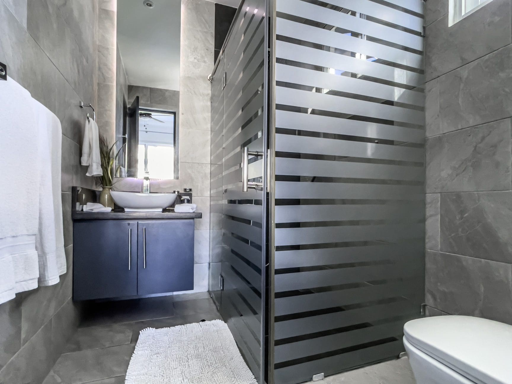 buyDRproperty Modern bathroom with frosted glass shower in a Sosúa Ocean Village villa for sale. Sosua Real Estate