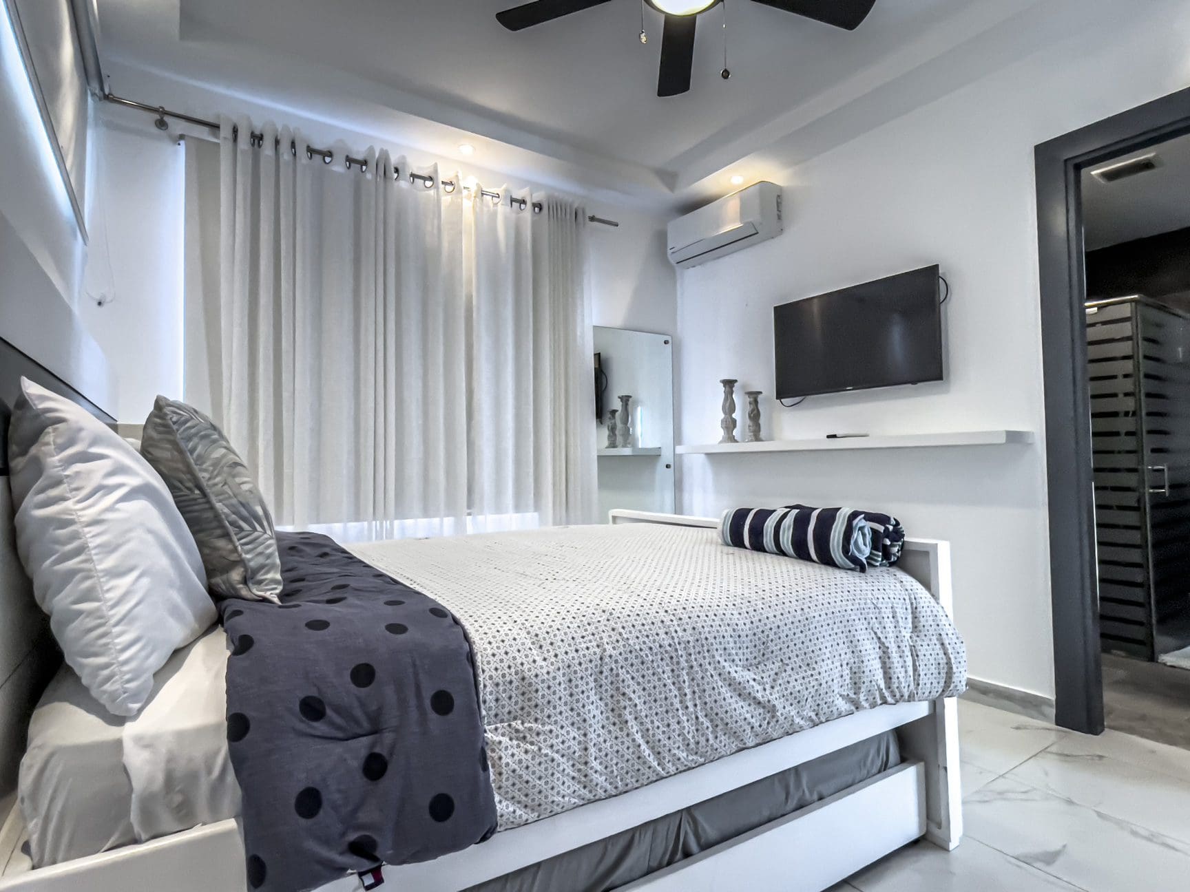 buyDRproperty Modern 3-bedroom villa bedroom in Sosúa Ocean Village with bed and TV. Sosua Real Estate