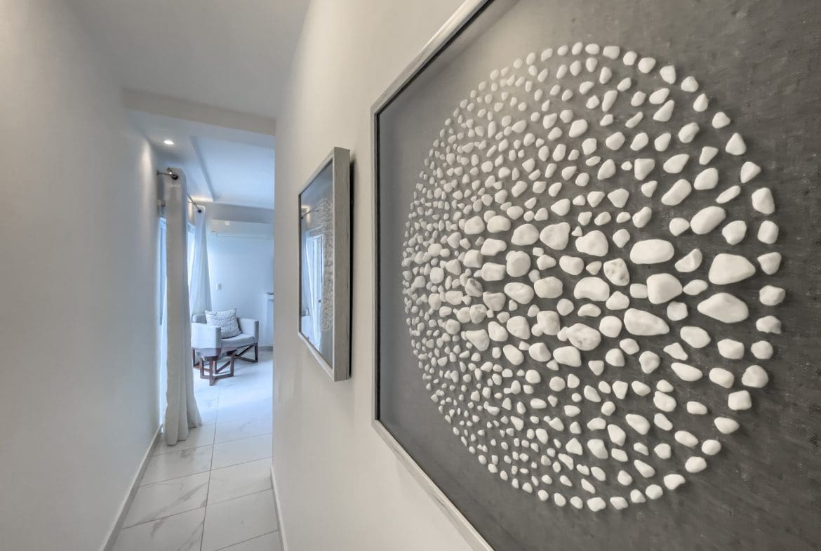 buyDRproperty Modern hallway in a Sosúa Ocean Village 3-bedroom villa for sale, featuring art. Sosua Real Estate