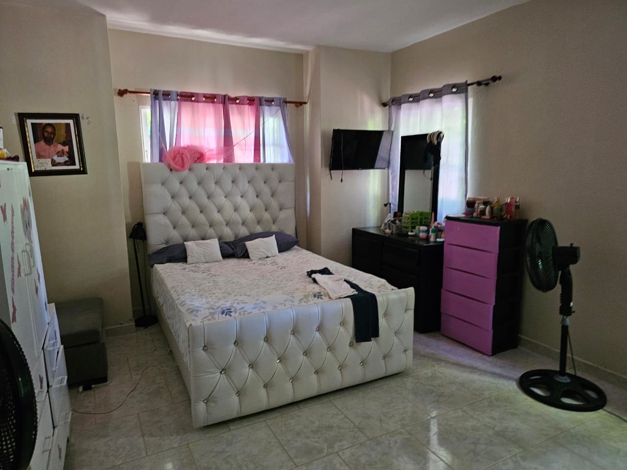 buyDRproperty Bedroom in a charming house for sale in Cabarete, featuring a tufted headboard bed. Sosua Real Estate
