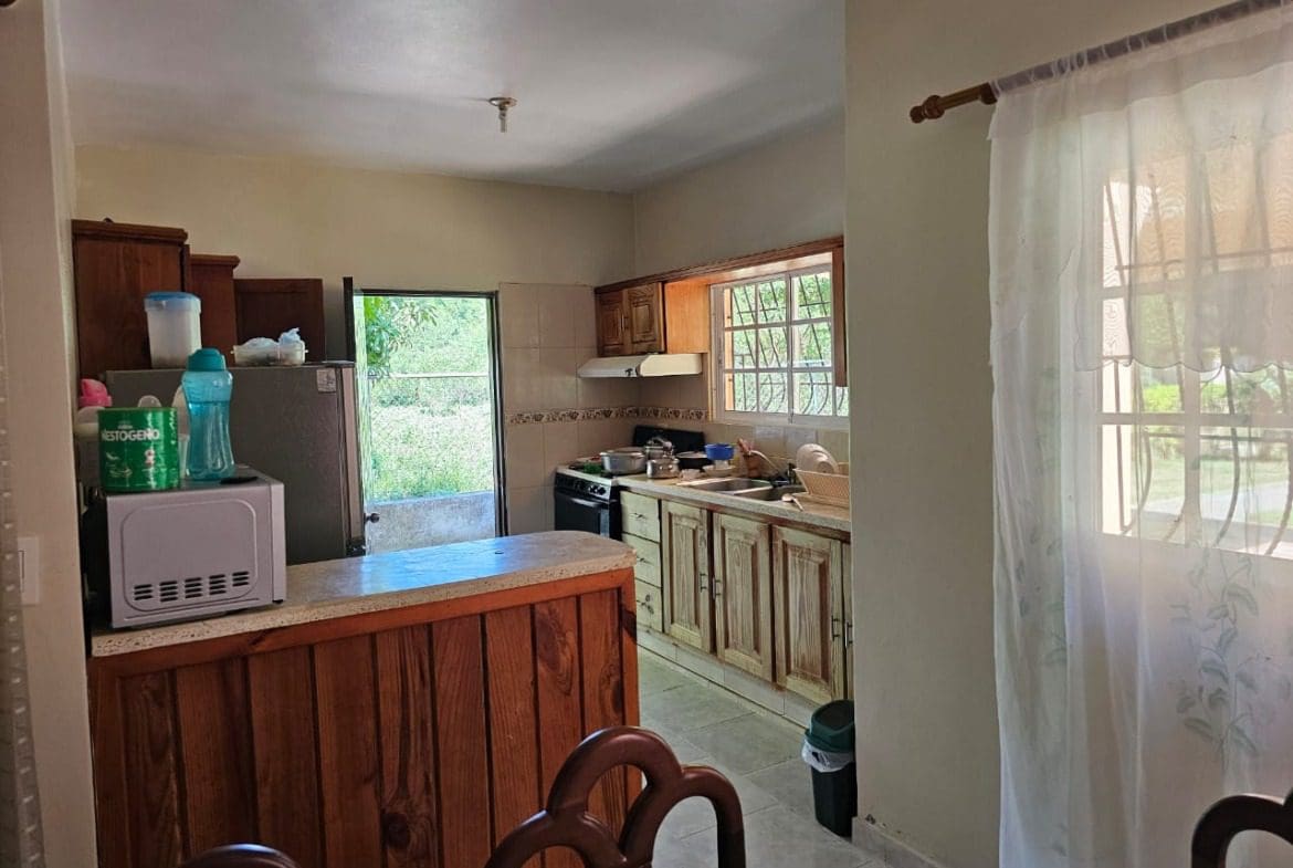 buyDRproperty Kitchen in a Cabarete house for sale, featuring wooden cabinets and a breakfast bar. Sosua Real Estate