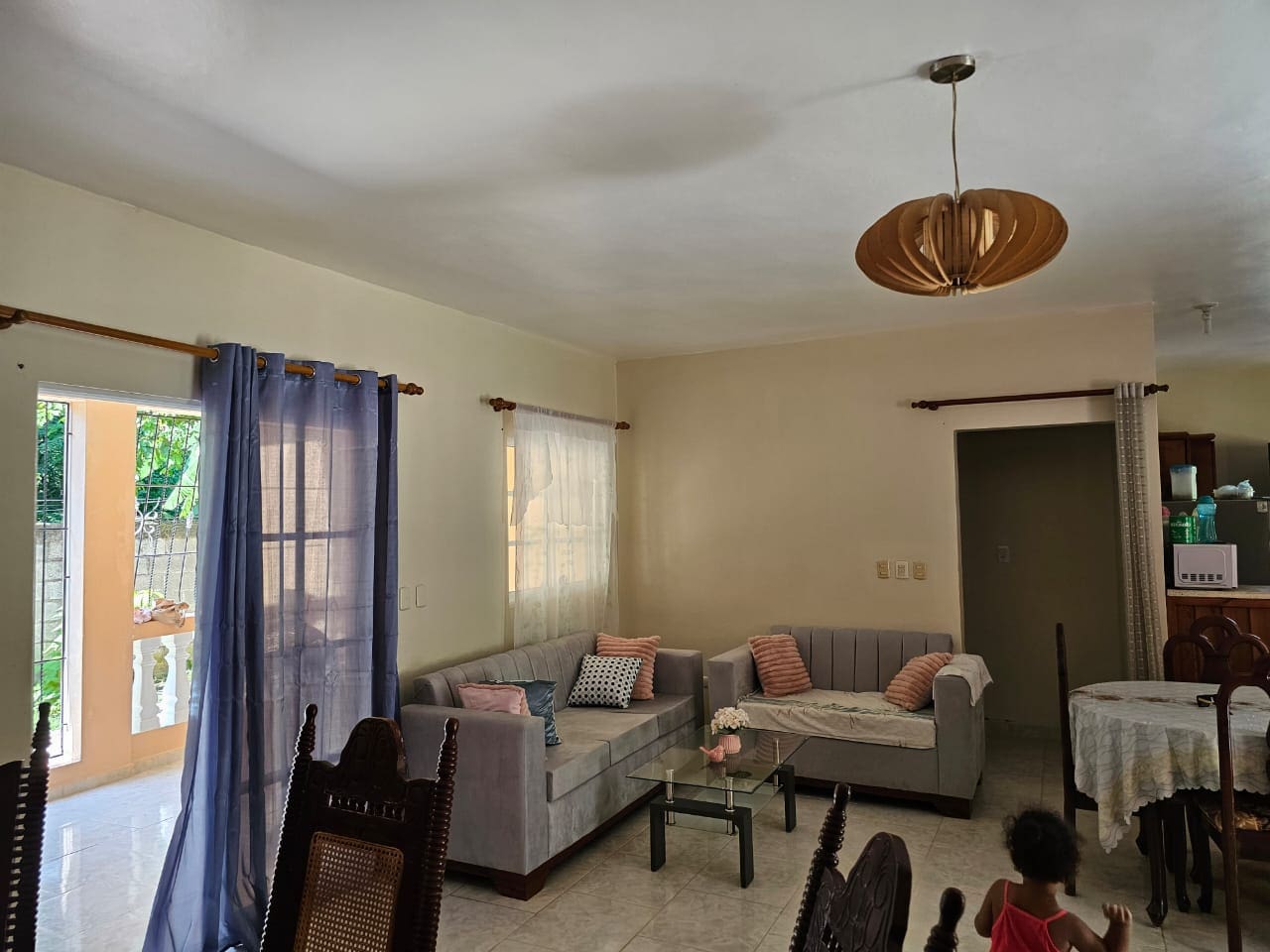 buyDRproperty Living room of a house for sale in Cabarete, with sofa, curtains, and light fixture. Sosua Real Estate