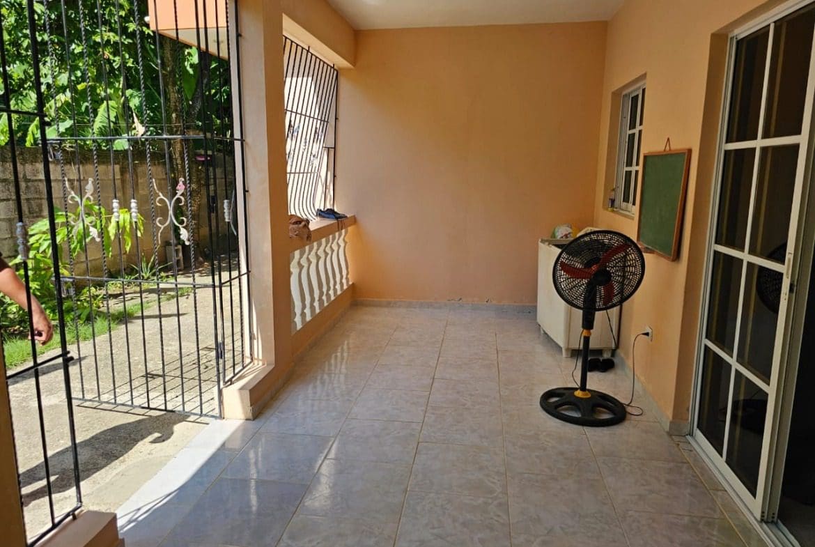 buyDRproperty Covered patio with tile floor, black gate, fan, and a door. Charming house in Cabarete for sale. Sosua Real Estate