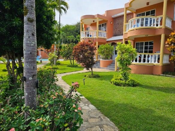 buyDRproperty Townhouse for sale close to SOSUA center with green lawns and a stone pathway. Sosua Real Estate