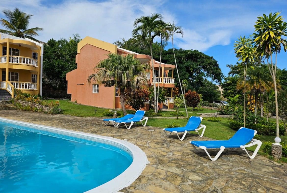 buyDRproperty Poolside view of a Great Condo for Sale with lounge chairs, near SOSUA Center Sosua Real Estate