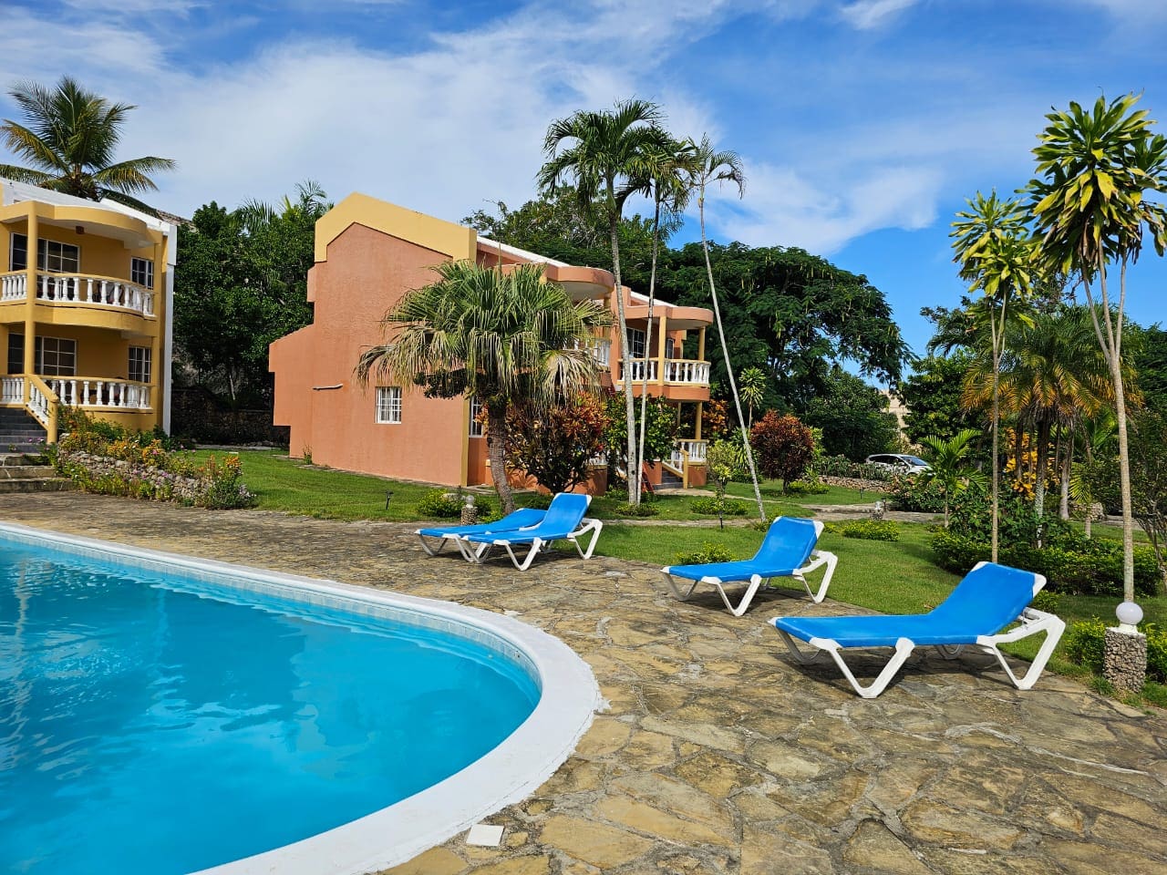 buyDRproperty Poolside view of a Great Condo for Sale with lounge chairs, near SOSUA Center Sosua Real Estate