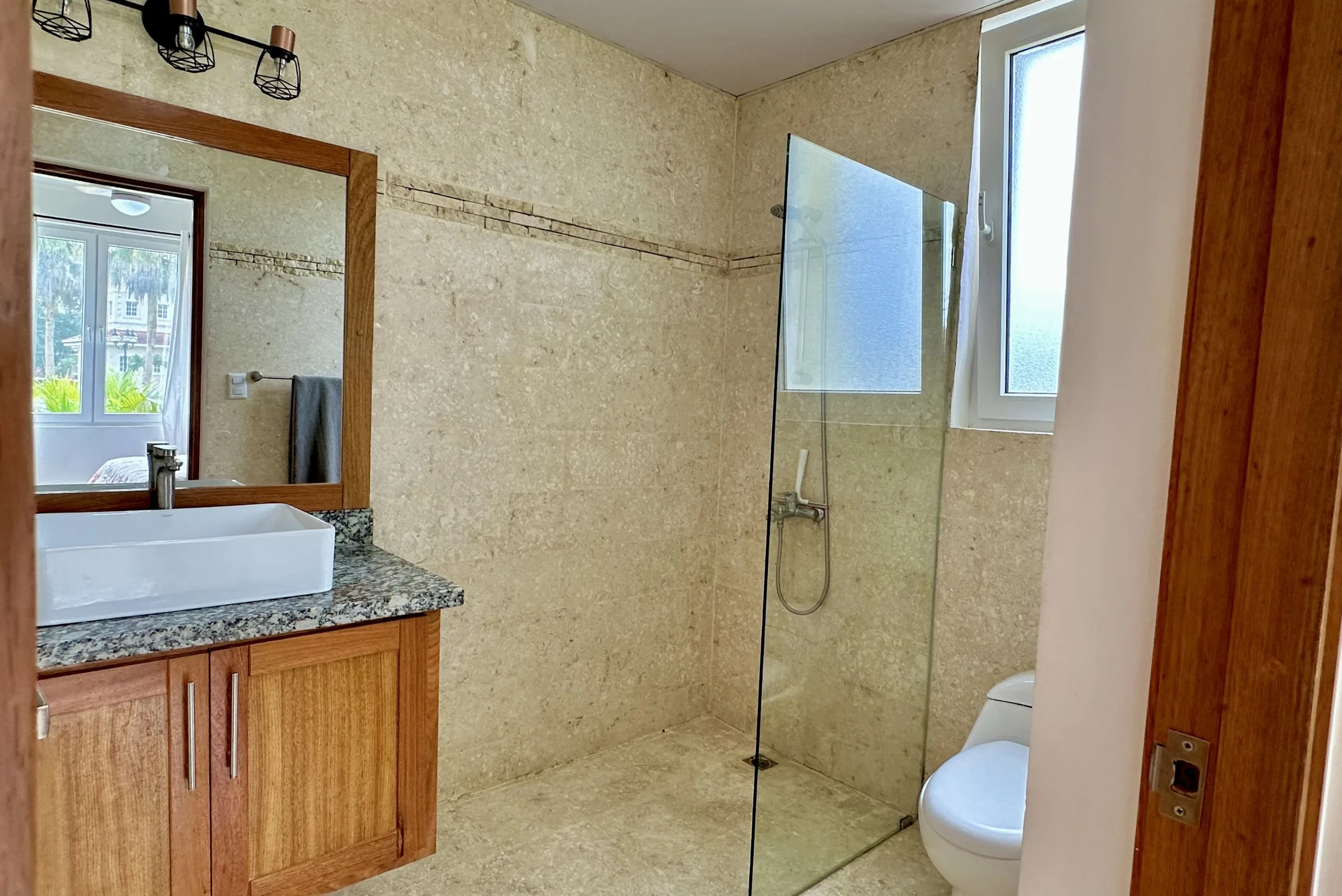 buyDRproperty Bathroom in a 2-bedroom condo for sale with a modern design, glass shower, and stylish vanity. Sosua Real Estate