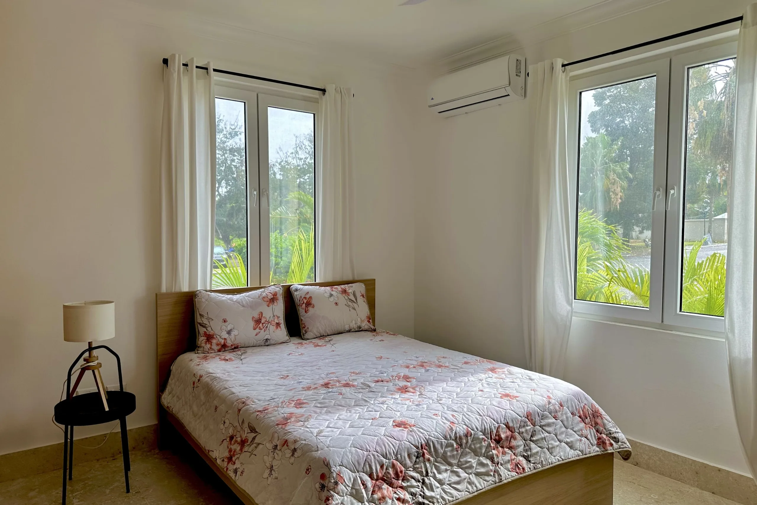 buyDRproperty Bright 2-bedroom condo bedroom with bed and windows. Sosua Real Estate