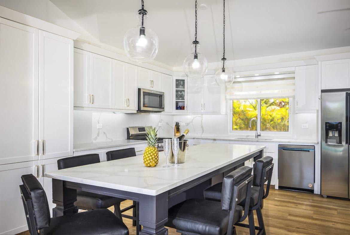 buyDRproperty Modern kitchen island in a villa for sale in Casa Linda with a pineapple and champagne. Sosua Real Estate