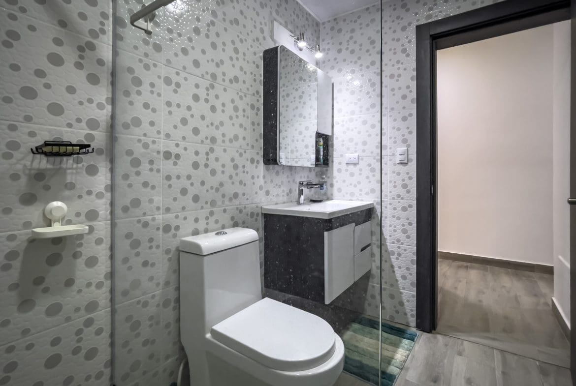 buyDRproperty Modern bathroom with a toilet, sink, and shower. One Bedroom Condo. Sosua Real Estate