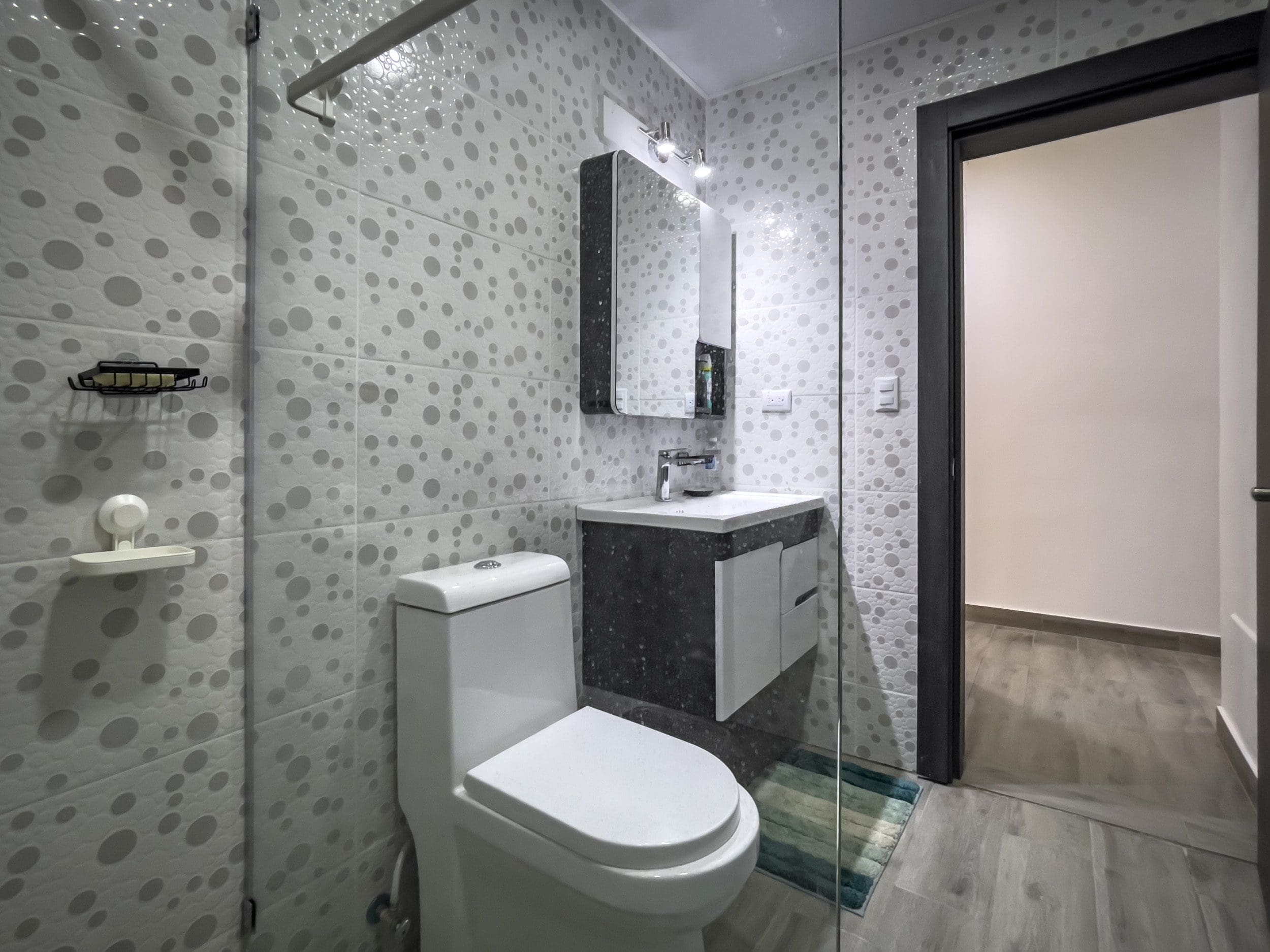buyDRproperty Modern bathroom with a toilet, sink, and shower. One Bedroom Condo. Sosua Real Estate