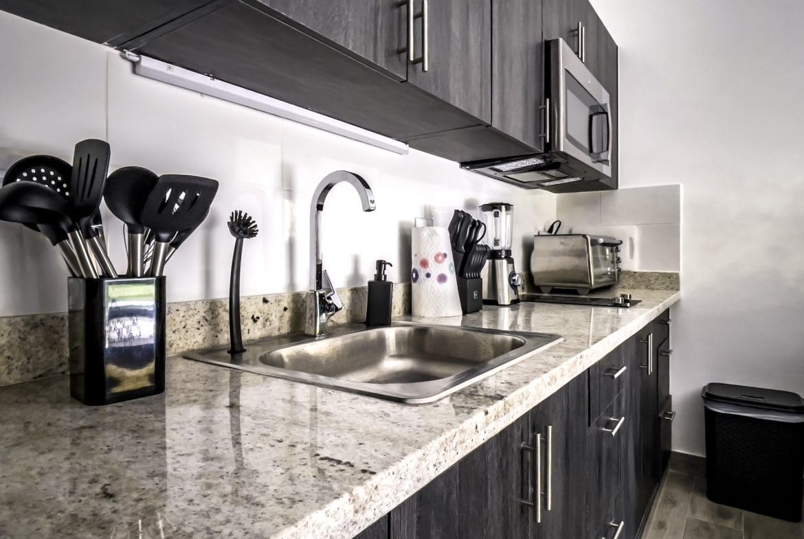 buyDRproperty Modern kitchen in one bedroom condo in Sosua with stainless steel appliances and granite countertop. Sosua Real Estate