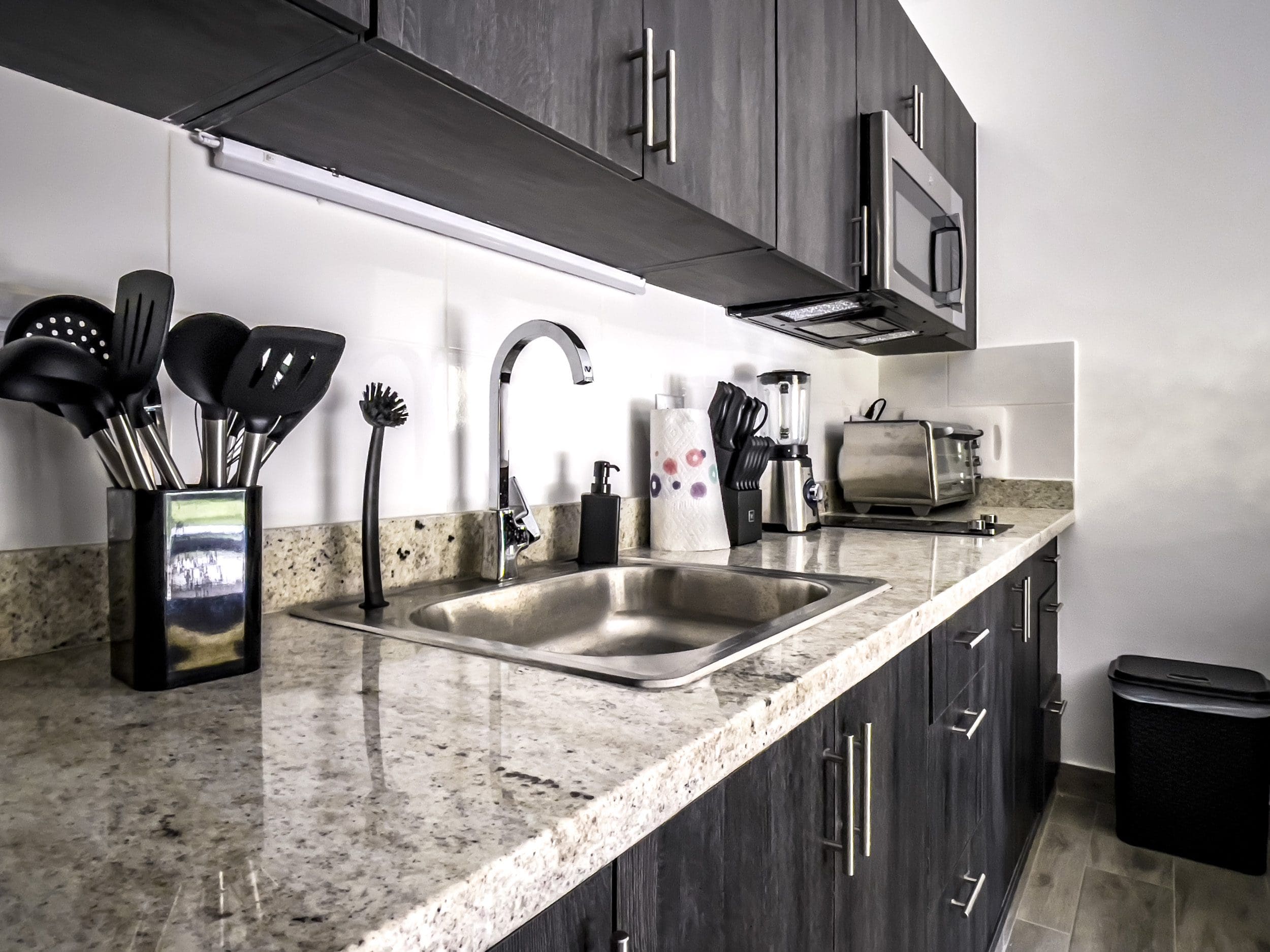 buyDRproperty Modern kitchen in one bedroom condo in Sosua with stainless steel appliances and granite countertop. Sosua Real Estate