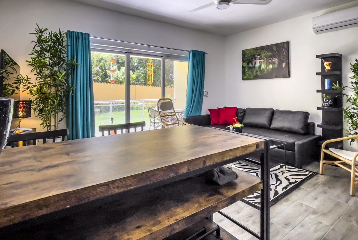 buyDRproperty Modern one-bedroom condo in Sosua, featuring a kitchen island and living room. Sosua Real Estate