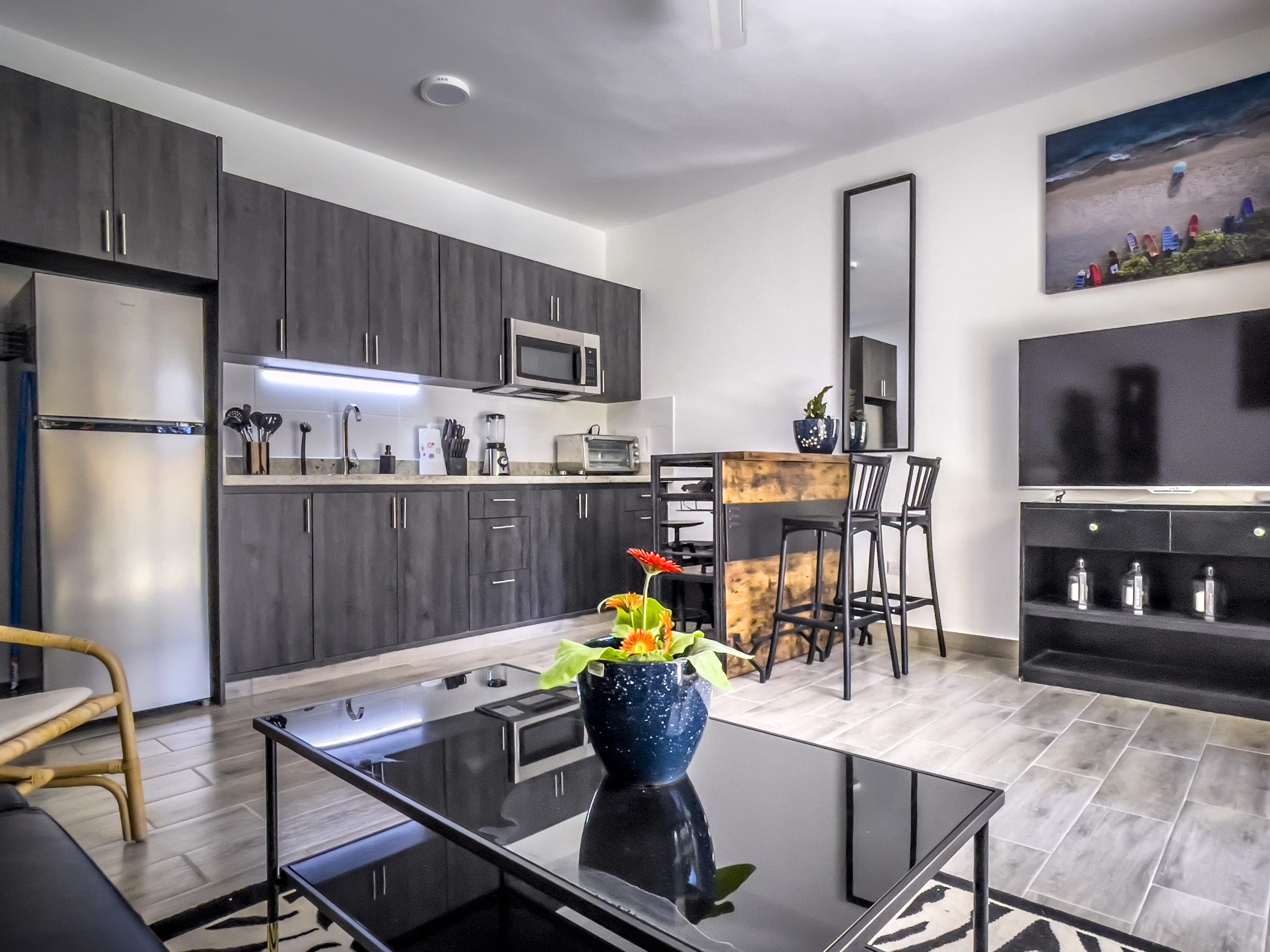 buyDRproperty Modern one bedroom condo kitchen with dark cabinets and bar Sosua Real Estate