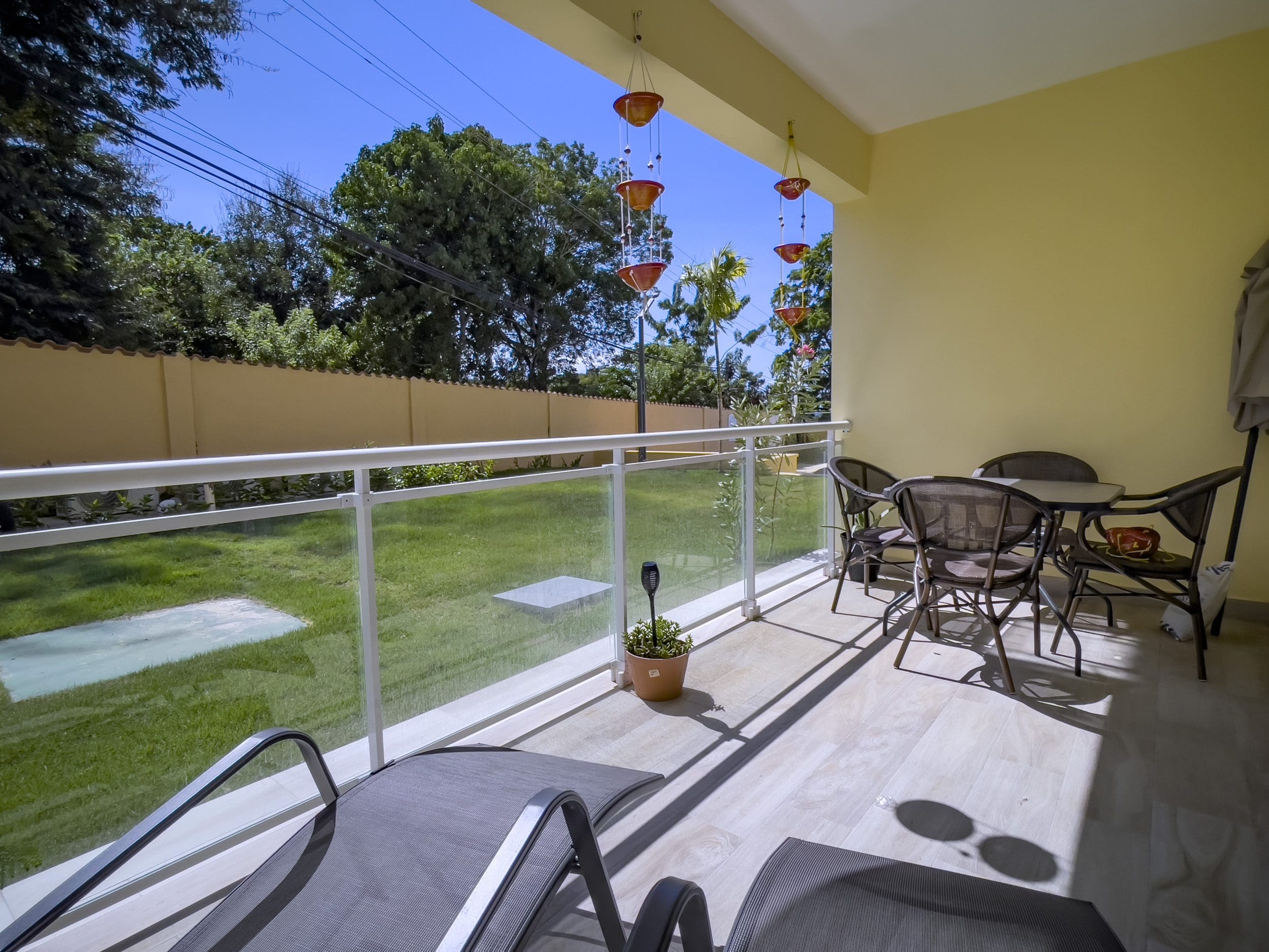 buyDRproperty Balcony of a one-bedroom condo for sale in Sosua with outdoor furniture, view of the yard, and hanging decor. Sosua Real Estate