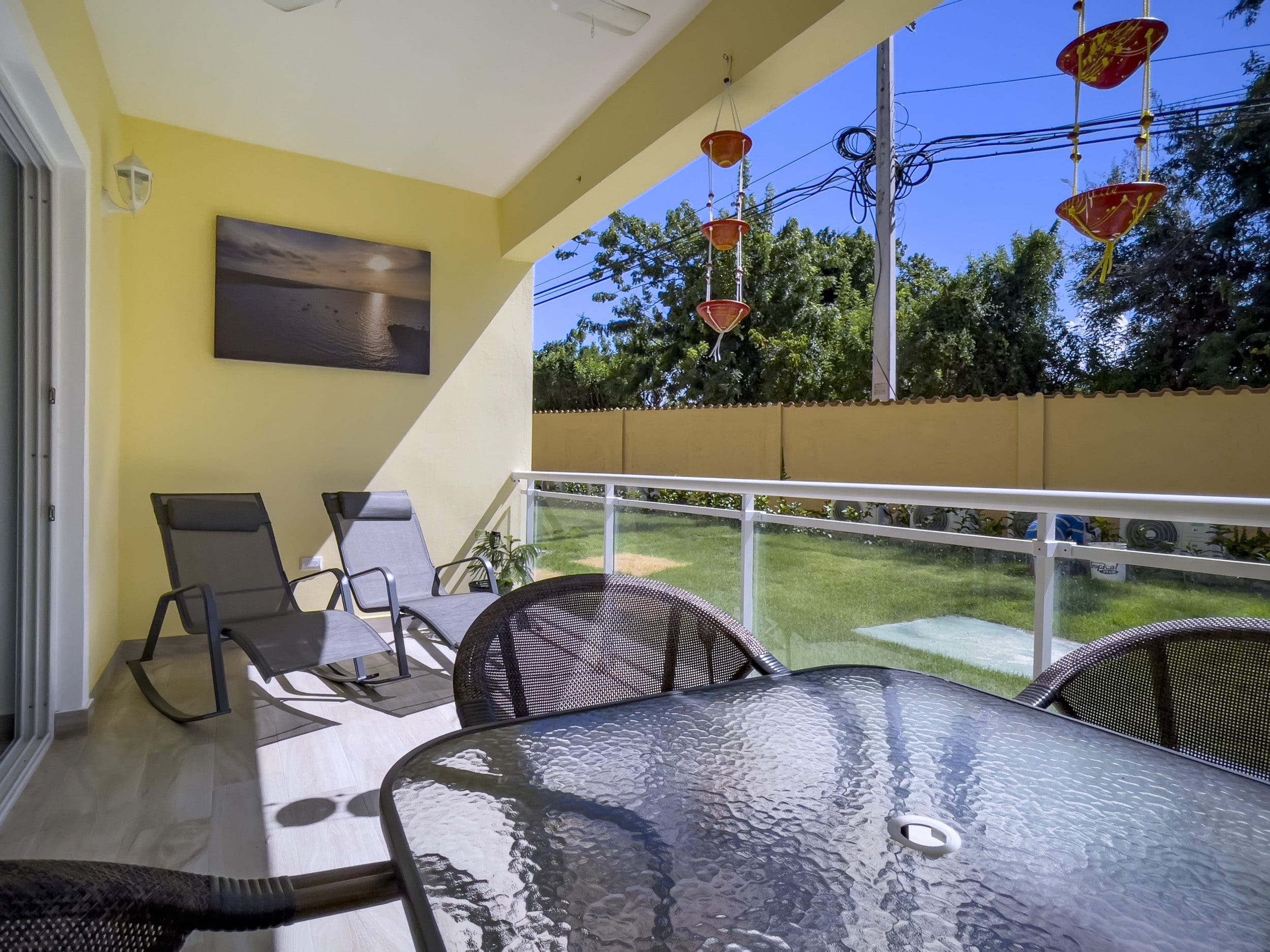 buyDRproperty Patio of a one bedroom condo in Sosua with glass table and chairs. Sosua Real Estate
