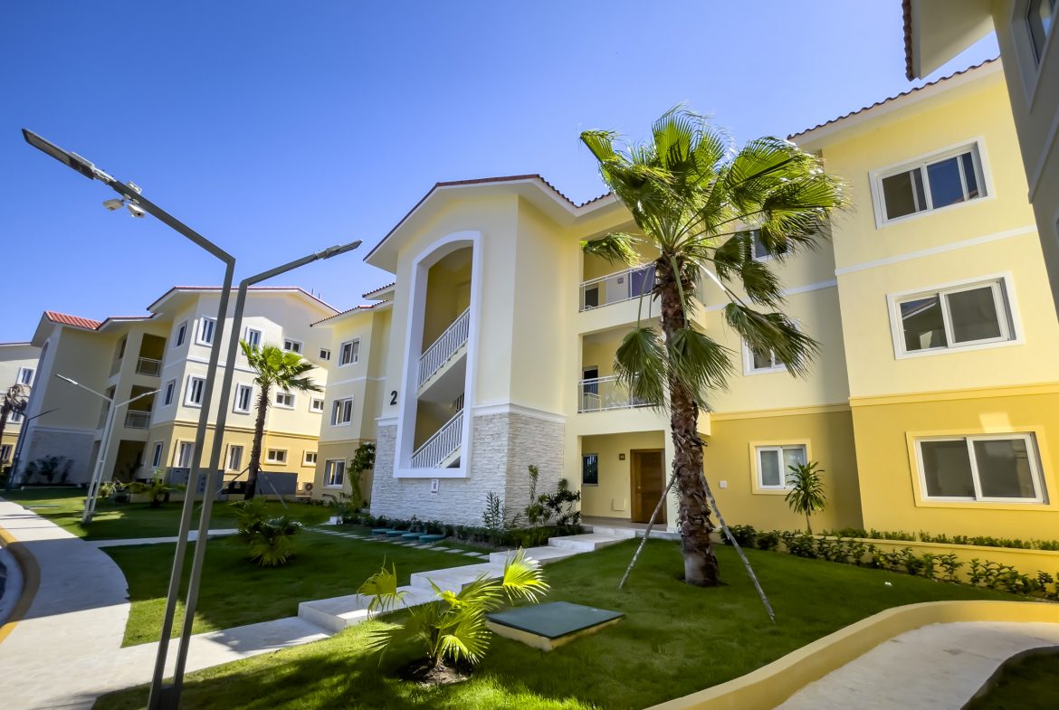 buyDRproperty Exterior view of a one-bedroom condo in Sosua with palm tree. Sosua Real Estate
