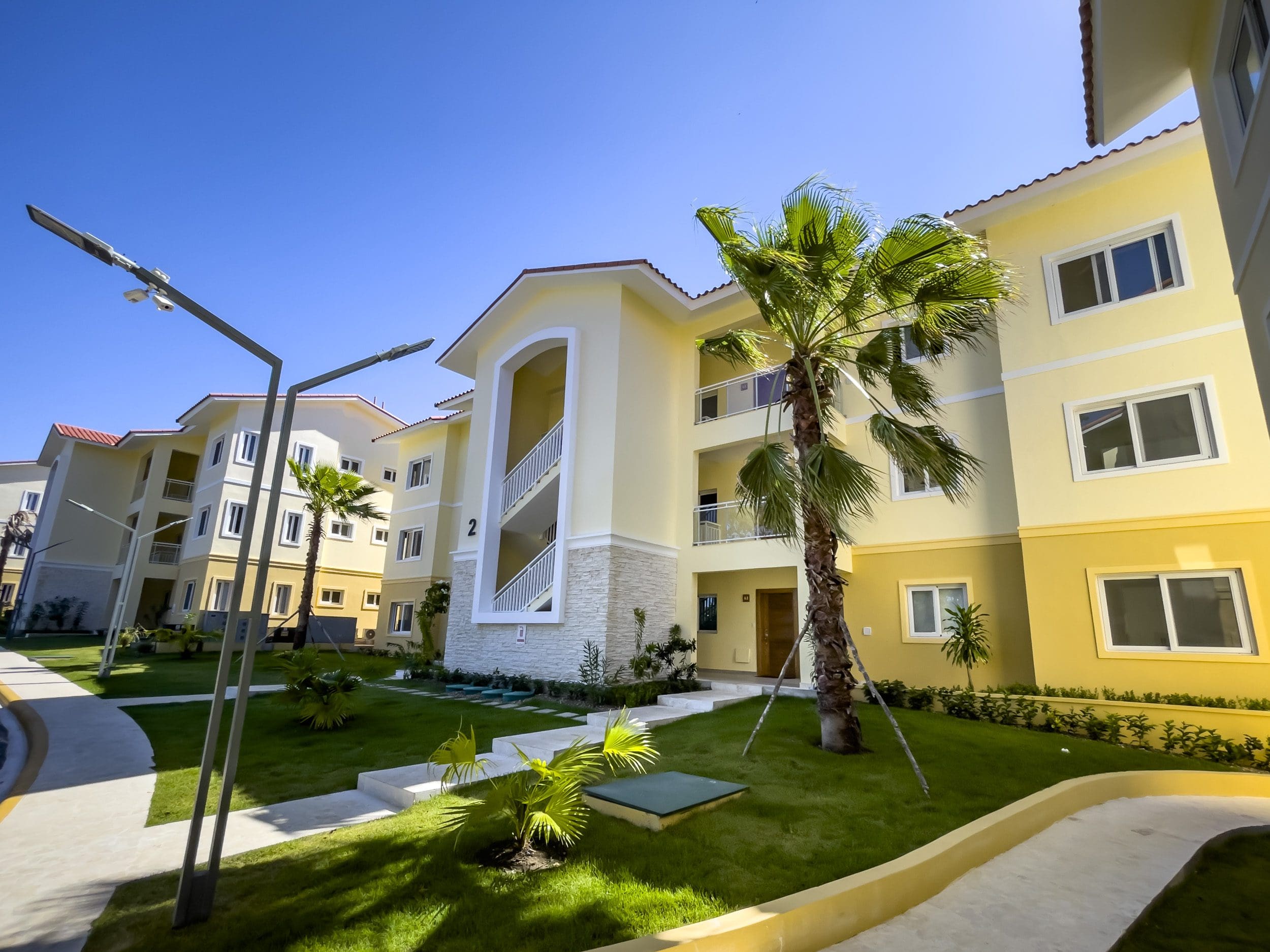 buyDRproperty Exterior view of a one-bedroom condo in Sosua with palm tree. Sosua Real Estate