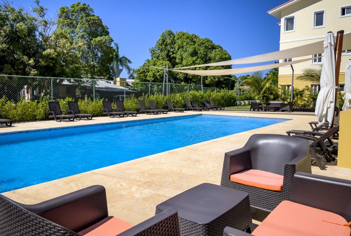 buyDRproperty Swimming pool with lounge chairs at a one-bedroom condo in Sosua. Sosua Real Estate