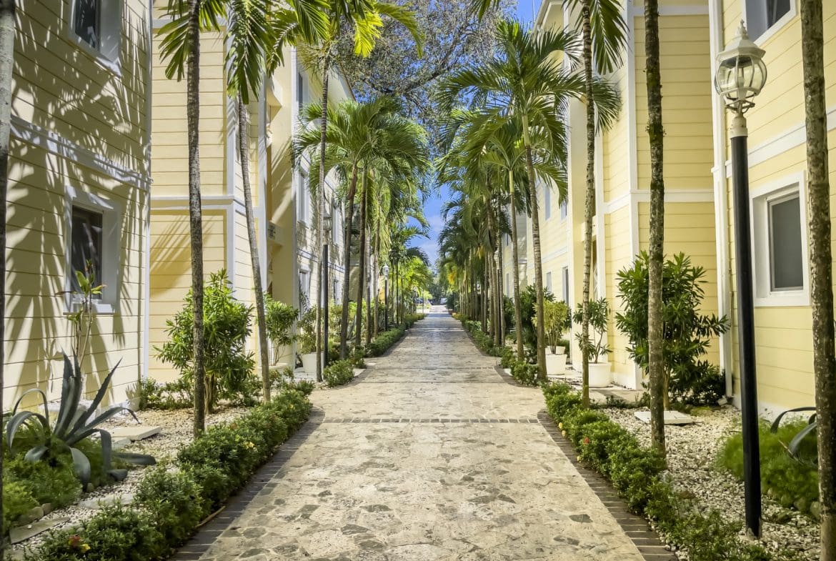buyDRproperty Pathway lined with palm trees and buildings, perfect for a 3 bedroom Pre-Construction For Sale. Sosua Real Estate