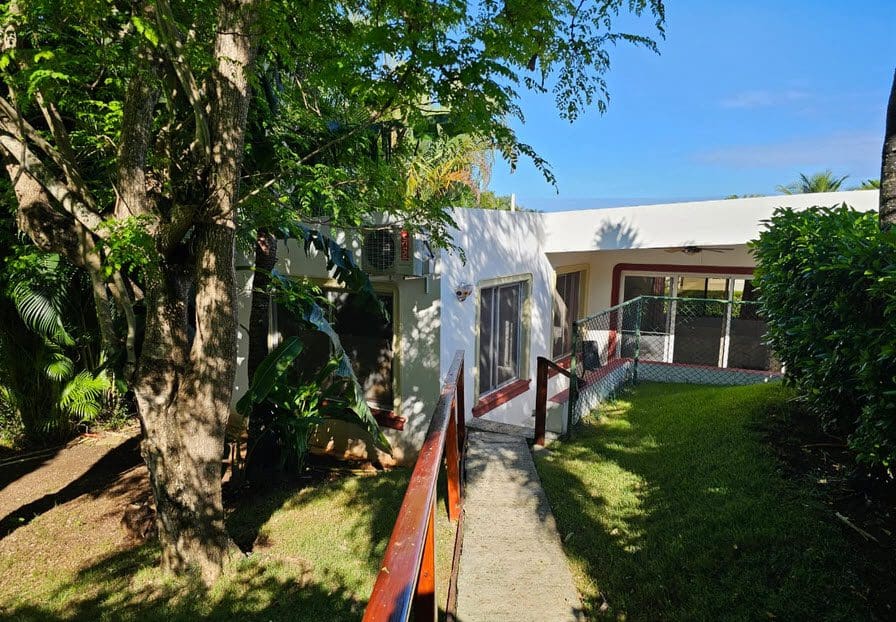 buyDRproperty Exterior view of Casa Linda Villa with lush landscaping and pathway. Sosua Real Estate