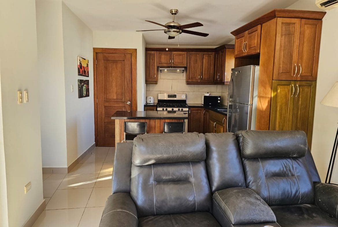 buyDRproperty Cozy kitchen in a Casa Linda Villa with wooden cabinets and a breakfast bar. Sosua Real Estate
