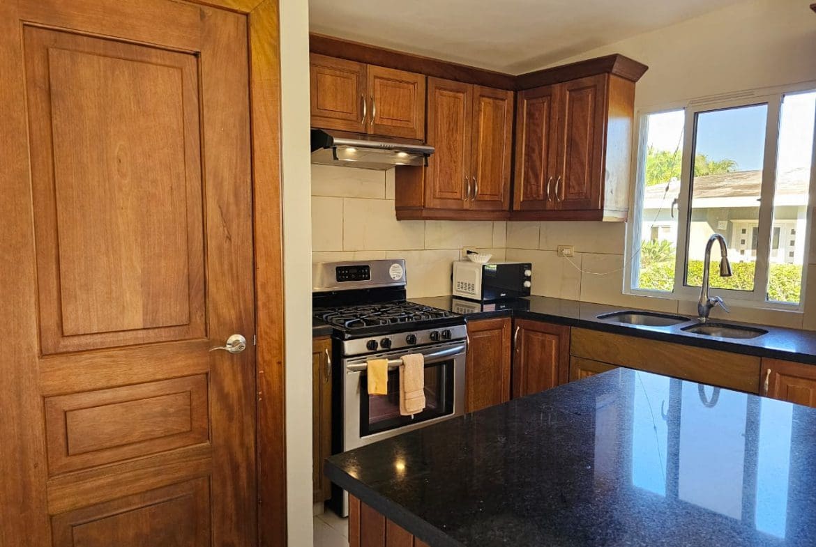buyDRproperty Casa Linda Villa kitchen with stainless steel stove and dark granite countertops. Sosua Real Estate