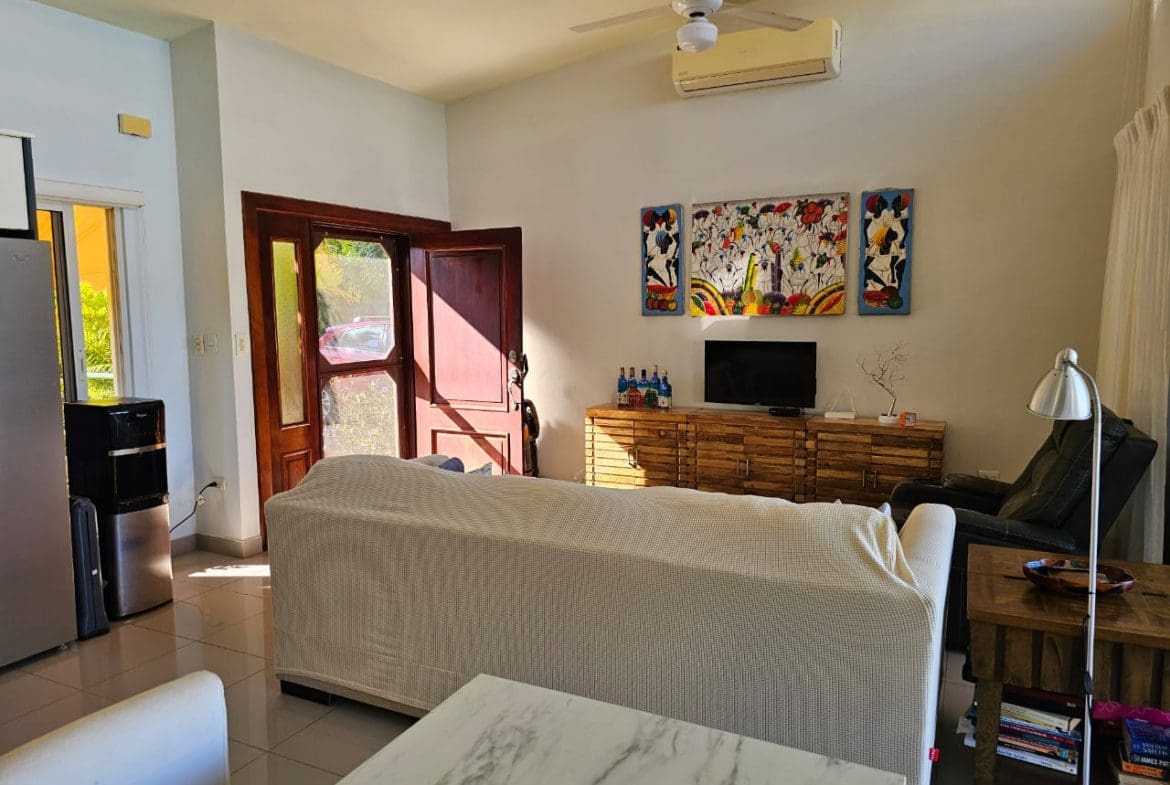 buyDRproperty Living room of a Casa Linda Villa with artwork, sofa, and open door. Sosua Real Estate