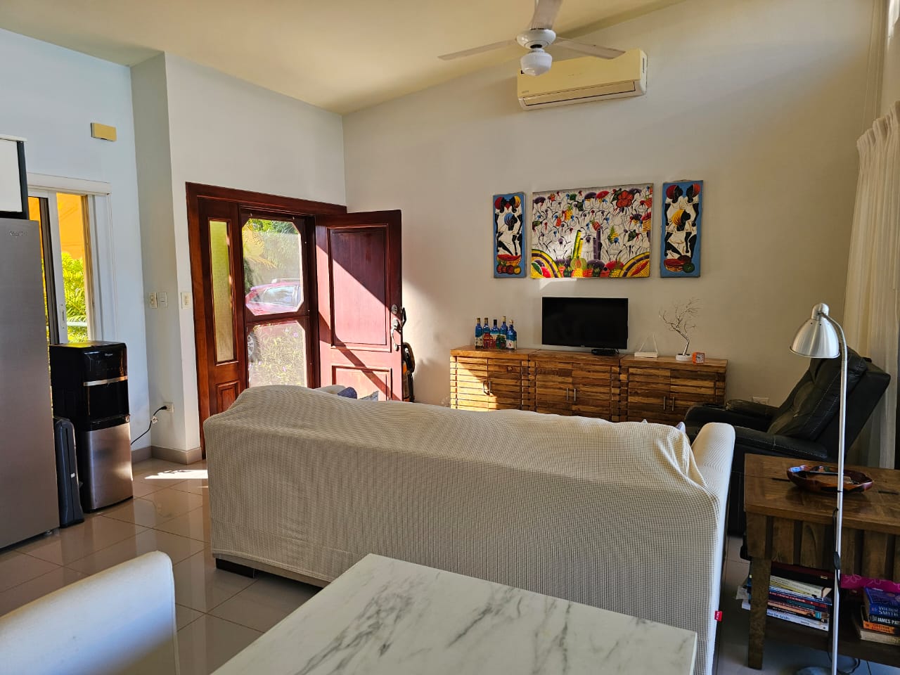 buyDRproperty Living room of a Casa Linda Villa with artwork, sofa, and open door. Sosua Real Estate