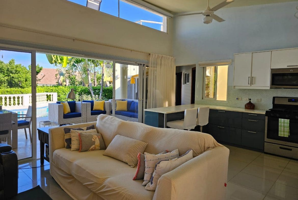 buyDRproperty Casa Linda Villa living room with open doors to a pool and outdoor seating. Sosua Real Estate