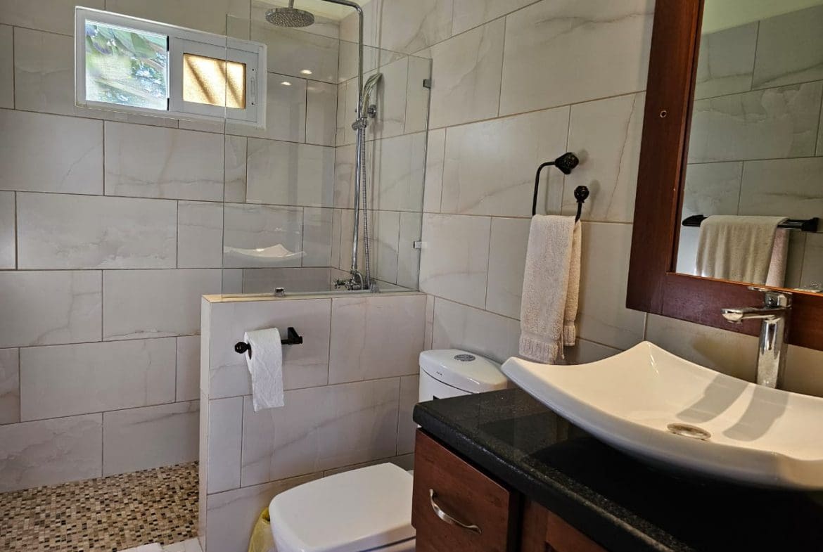 buyDRproperty Modern bathroom with shower, toilet, and sink in a Casa Linda Villa. Sosua Real Estate
