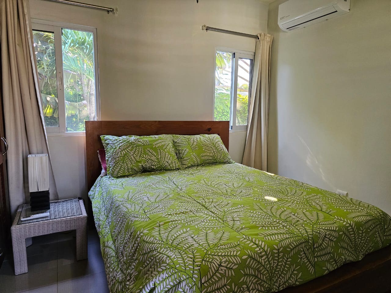 buyDRproperty Bedroom in a Casa Linda Villa with green fern bedding and a wooden headboard. Sosua Real Estate