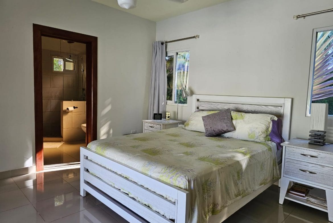 buyDRproperty Bedroom in a Casa Linda Villa with white bed frame and ensuite bathroom. Sosua Real Estate