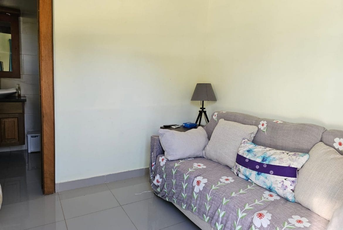 buyDRproperty Cozy living room in a Casa Linda Villa with floral sofa and lamp. Sosua Real Estate