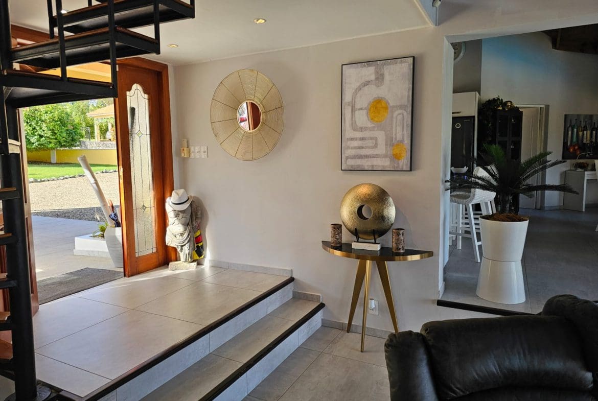 buyDRproperty Villa entrance with spiral staircase, modern decor, and open doorway leading to Ocean Views. Sosua Real Estate