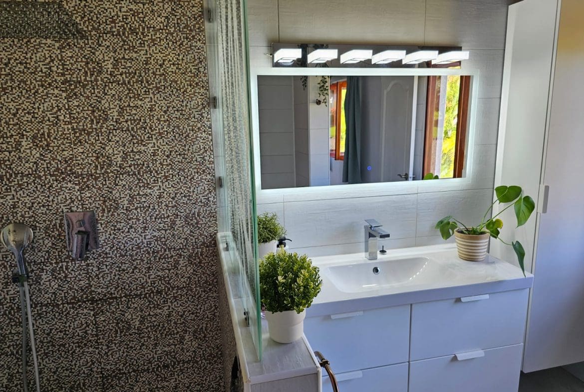 buyDRproperty Modern bathroom with illuminated mirror and mosaic shower. Ocean Views Villa. Sosua Real Estate