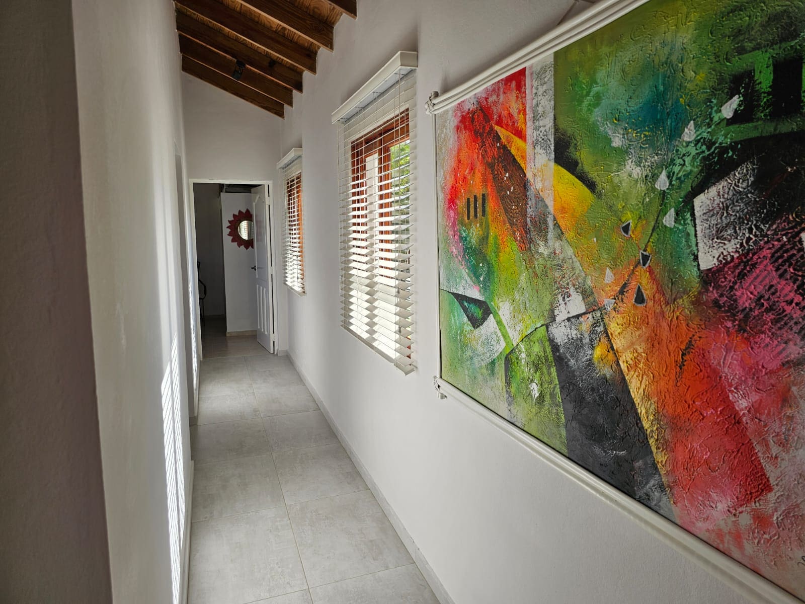 buyDRproperty Hallway in a luxury villa with modern art, tile floor, and windows. Villa for sale with ocean views. Sosua Real Estate